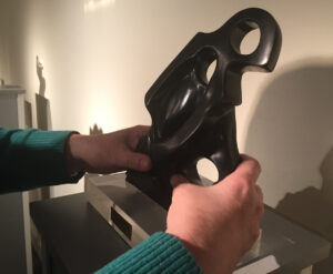 Manos de una persona ciega tocando una escultura
