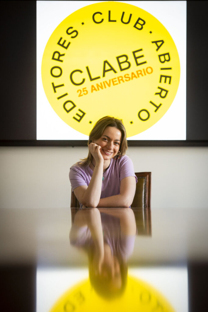 Mujer sonriente en reunión del Club Abierto de Editores