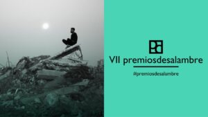 Hombre sentado en escombros con el sol de fondo en la VII edición de los Premios Desalambre.