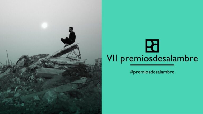 Hombre sentado en escombros con el sol de fondo en la VII edición de los Premios Desalambre.