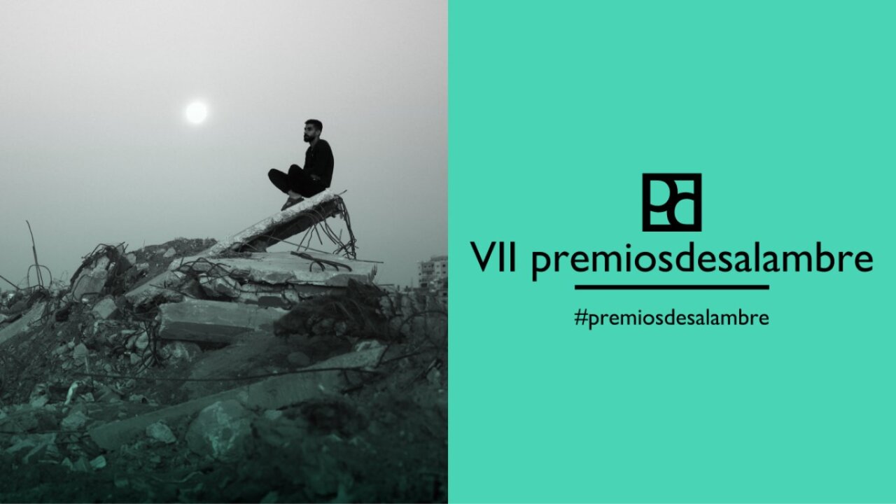 Hombre sentado en escombros con el sol de fondo en la VII edición de los Premios Desalambre.